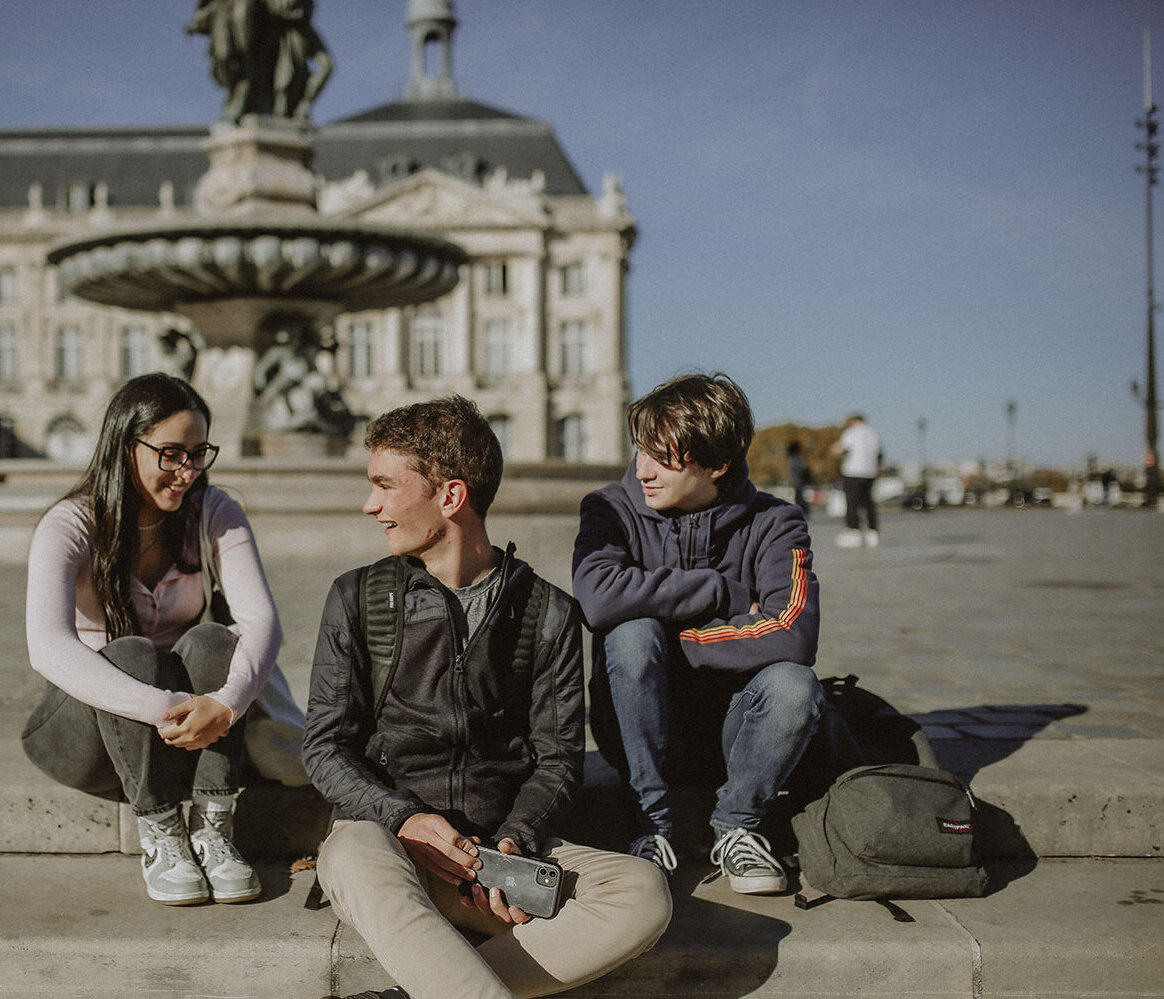 étudiants assis sur la place de la Bourse à Bordeaux