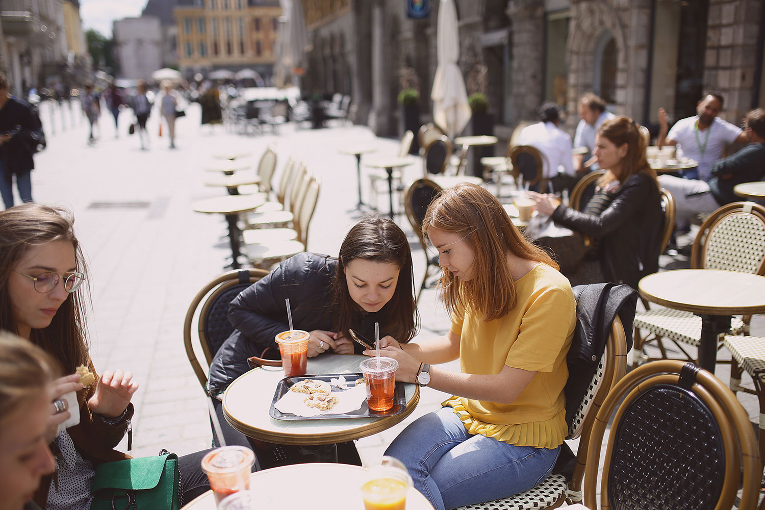 Des étudiants à la terrasse d'un café en train de boire et manger