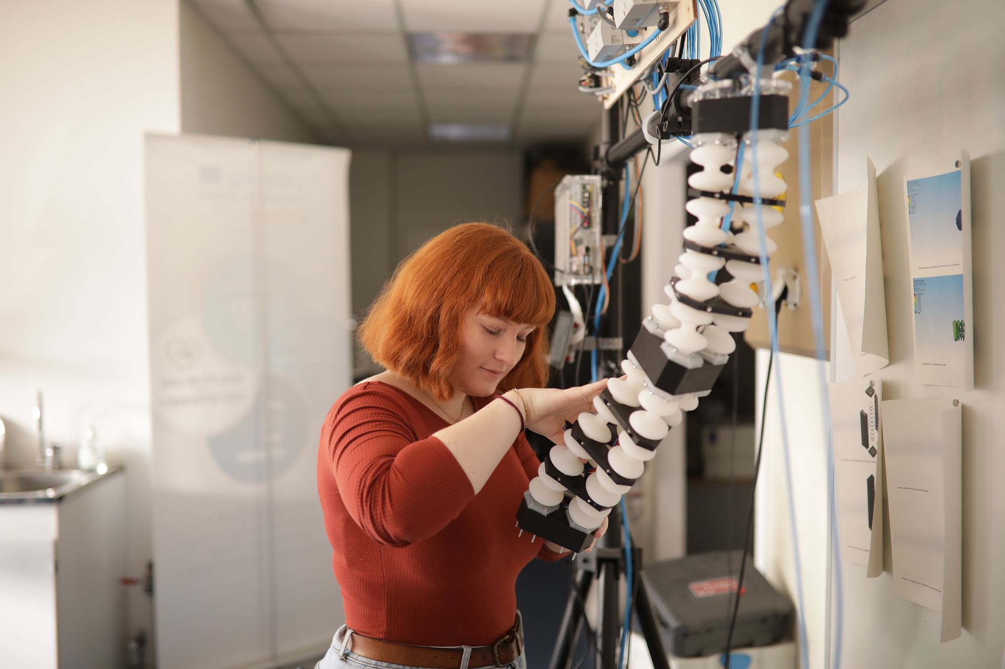 étudiante travaillant sur un bras électronique