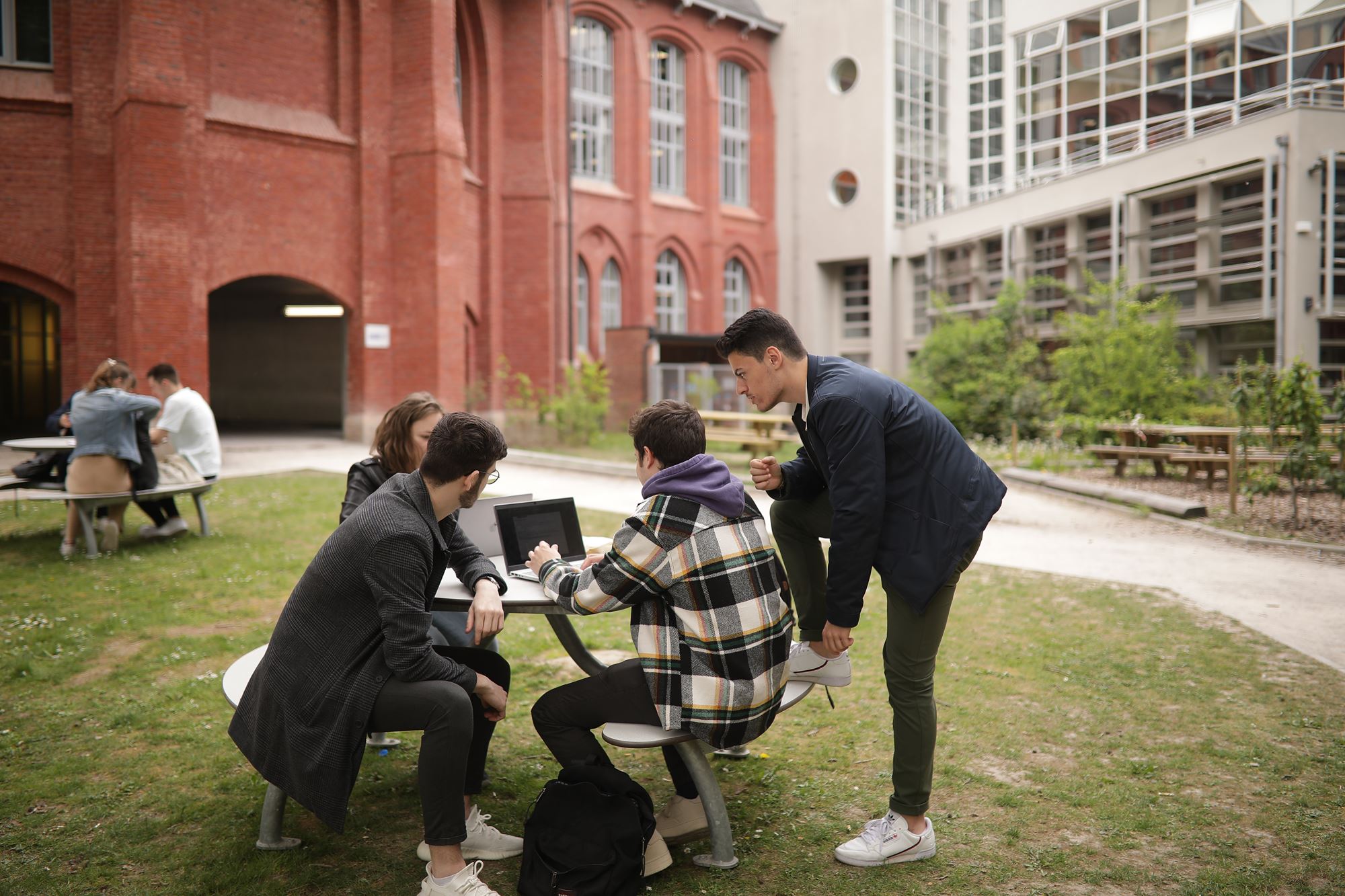 étudiants travaillant sur une table dans les jardins d'HEI