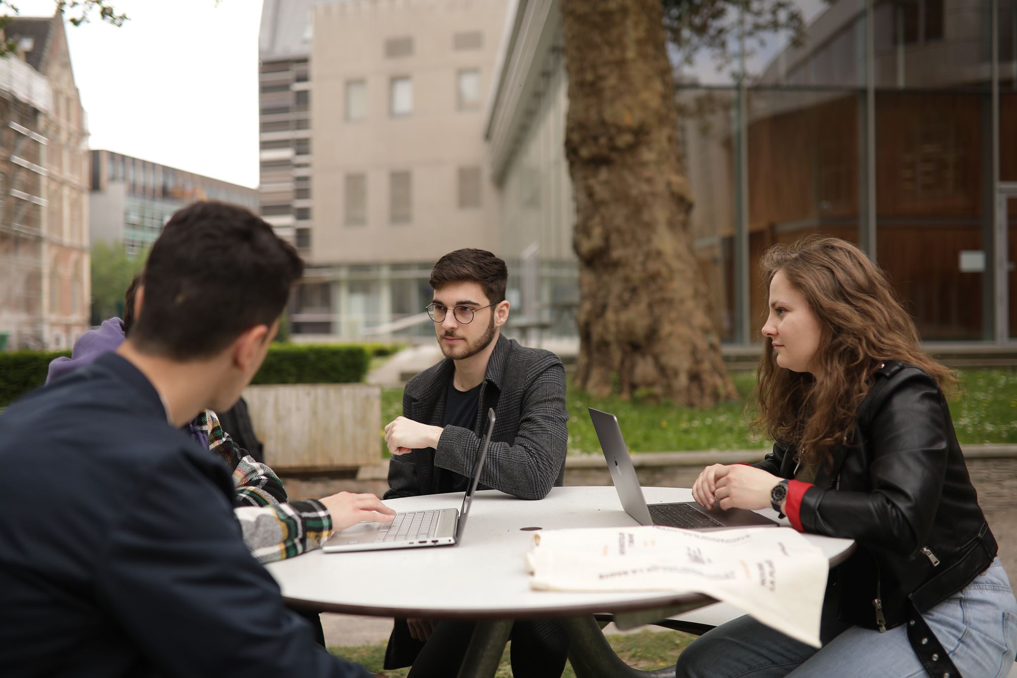 Des étudiants en train de travailler autour d'une table en extérieur dans les jardins d'HEI