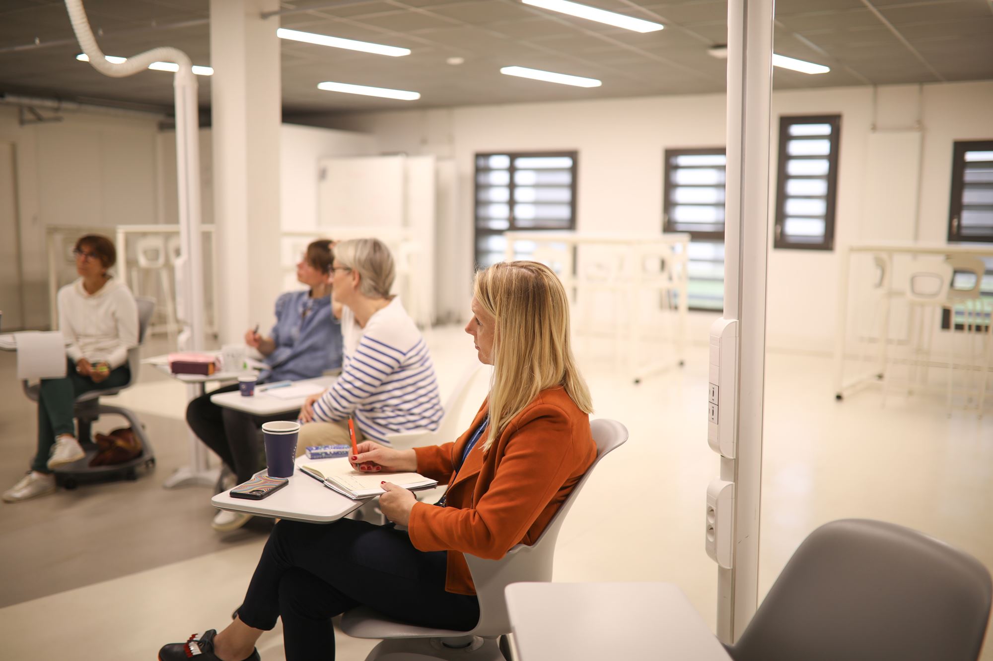 Une professionnelle en train de prendre des notes pendant sa formation chez JUNIA