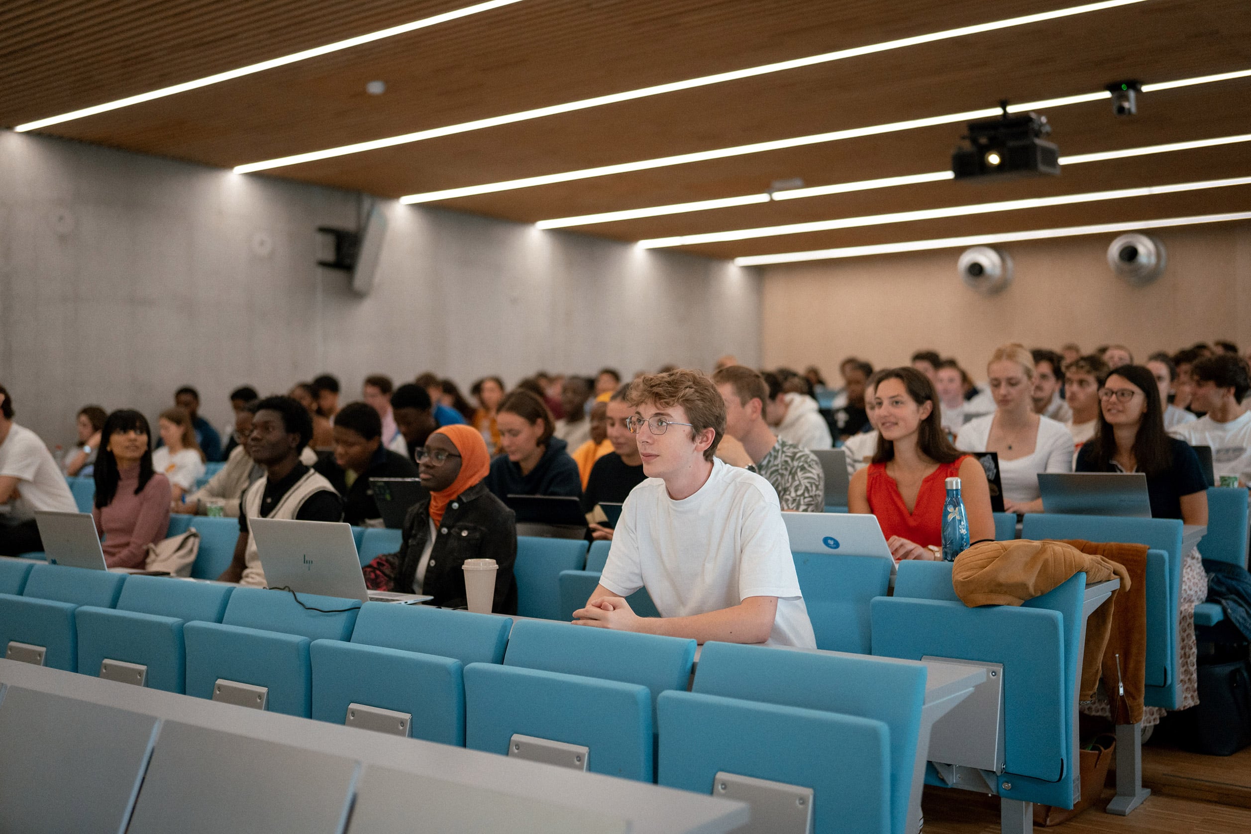 Des étudiants suivent un cours dans un amphithéâtre