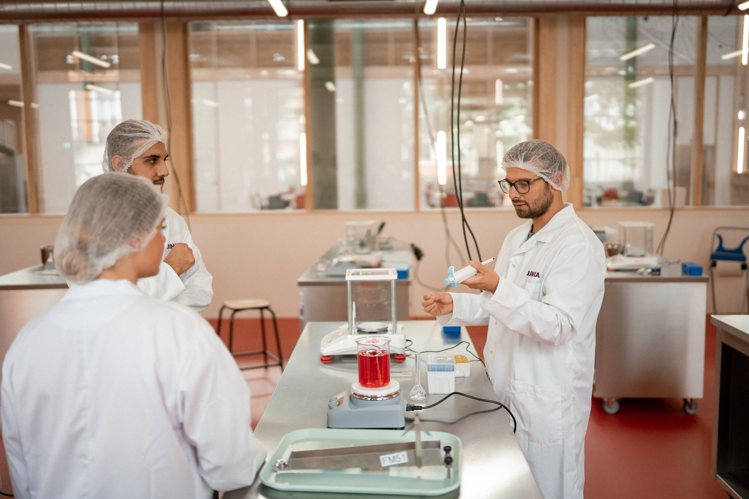 Un professeur donne un cours dans la cuisine expérimentale, habillé en blouse