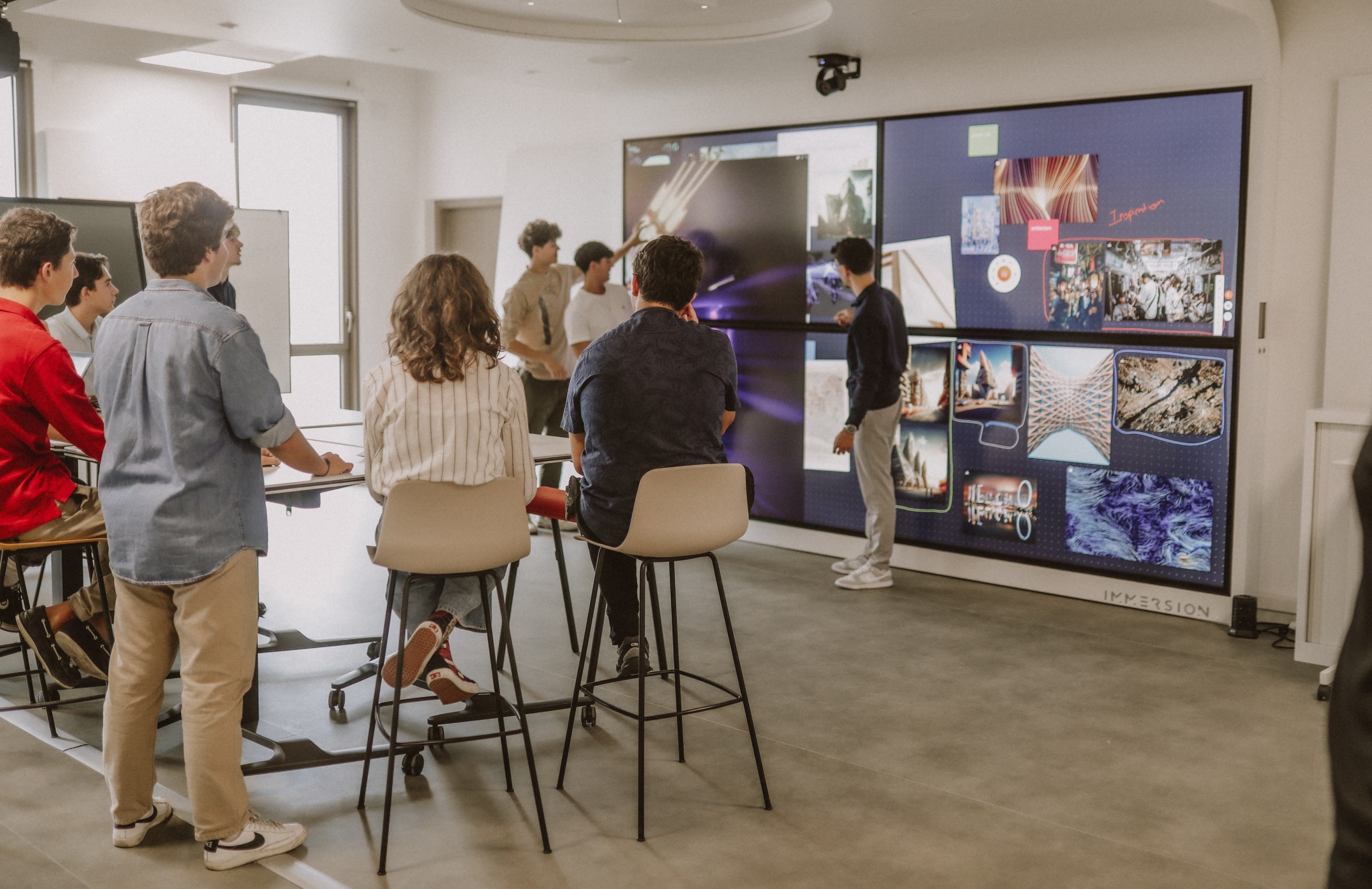 Des étudiants font une présentation sur l'écran tactile de la salle immersive du campus de Bordeaux