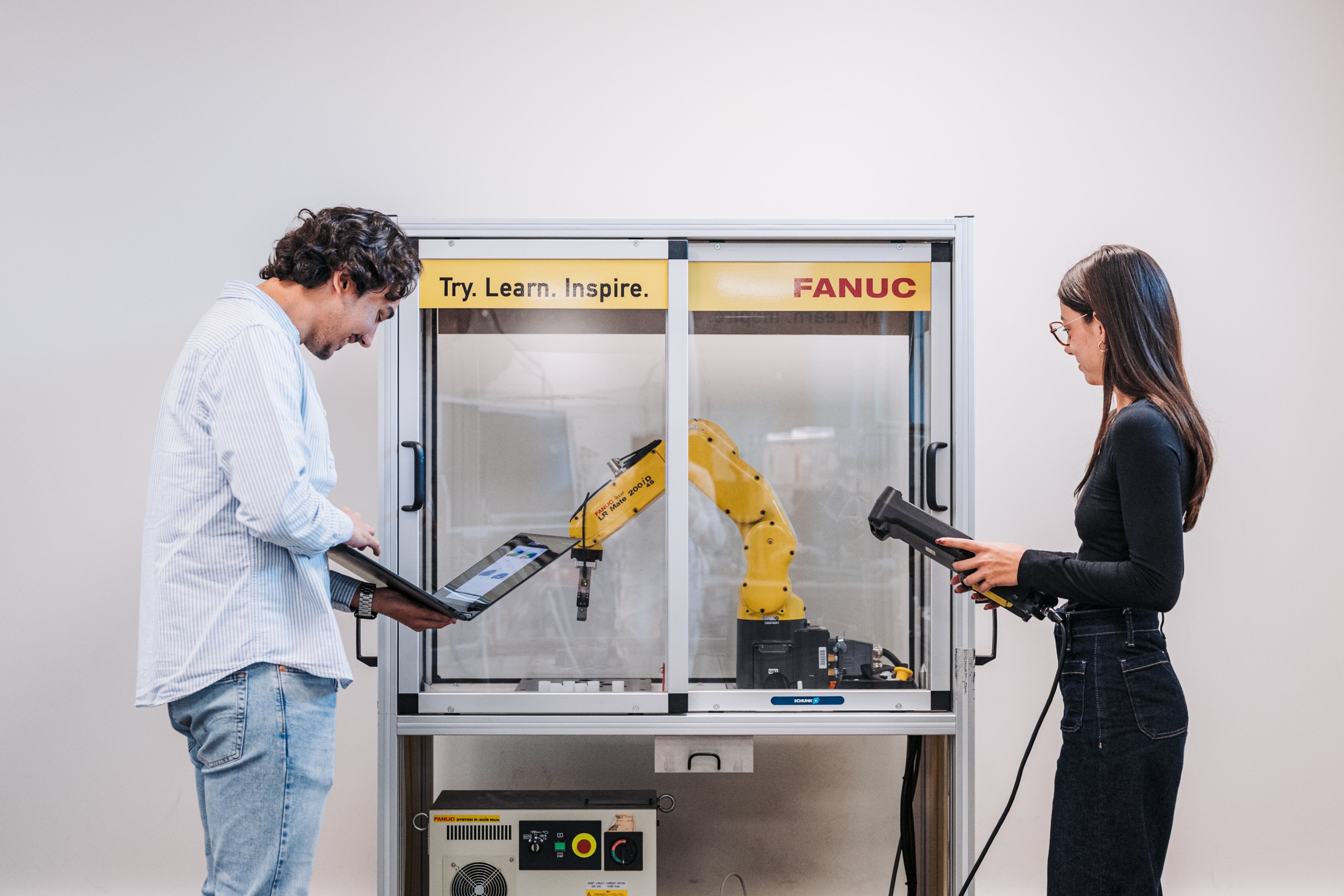 Deux étudiants travaillent avec un bras mécanique