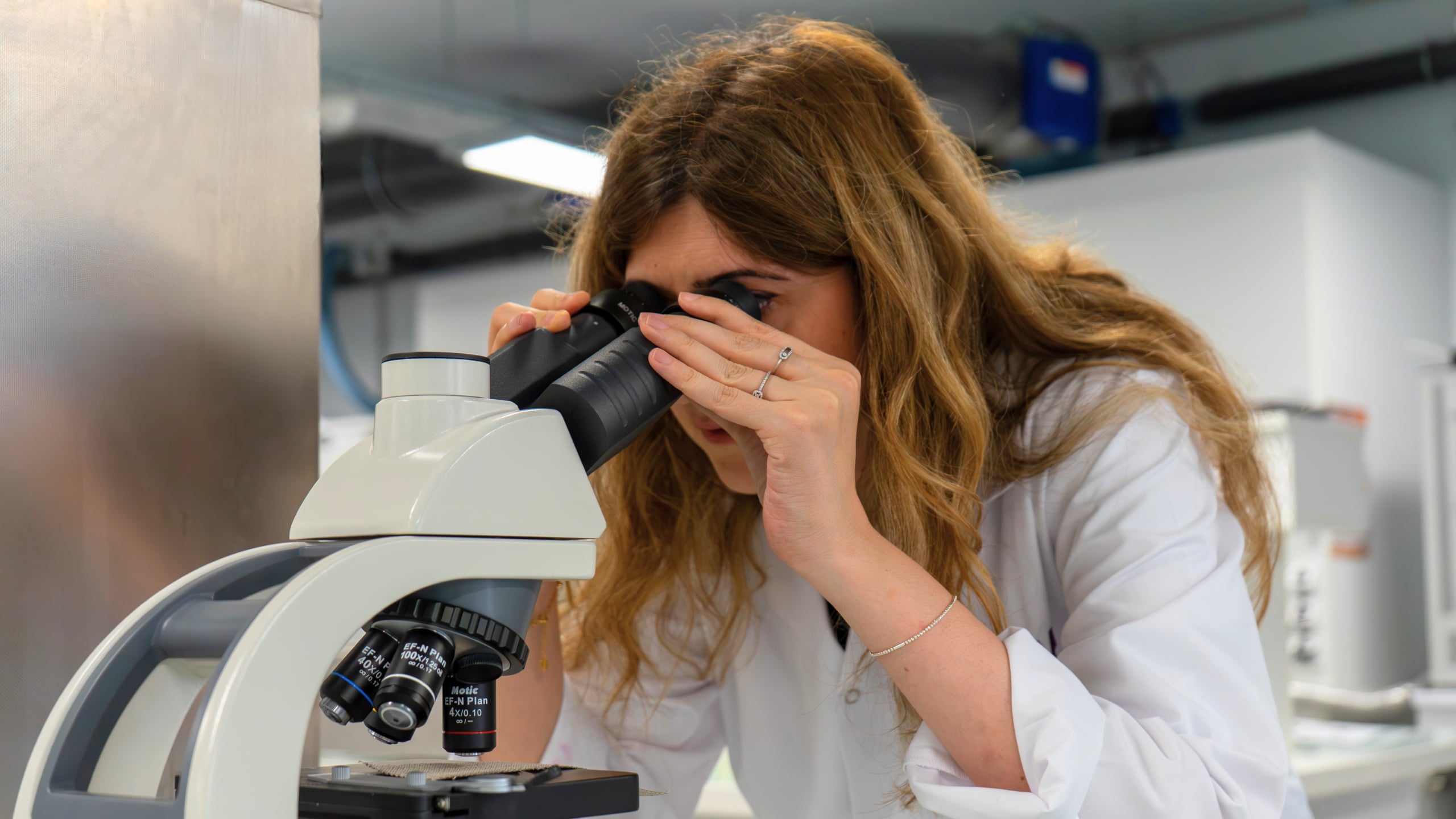 Une enseignante regarde dans un microscope