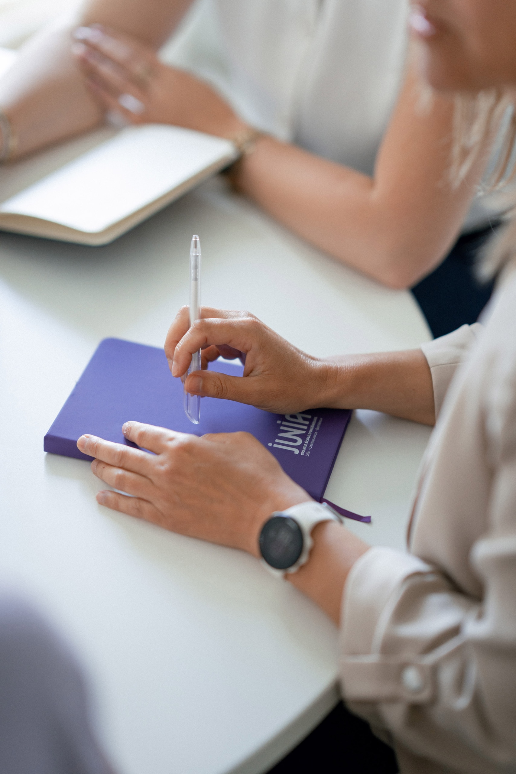Un carnet JUNIA avec un détail sur la main