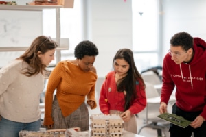 Un groupe de 4 étudiants au-dessus d'une maquette