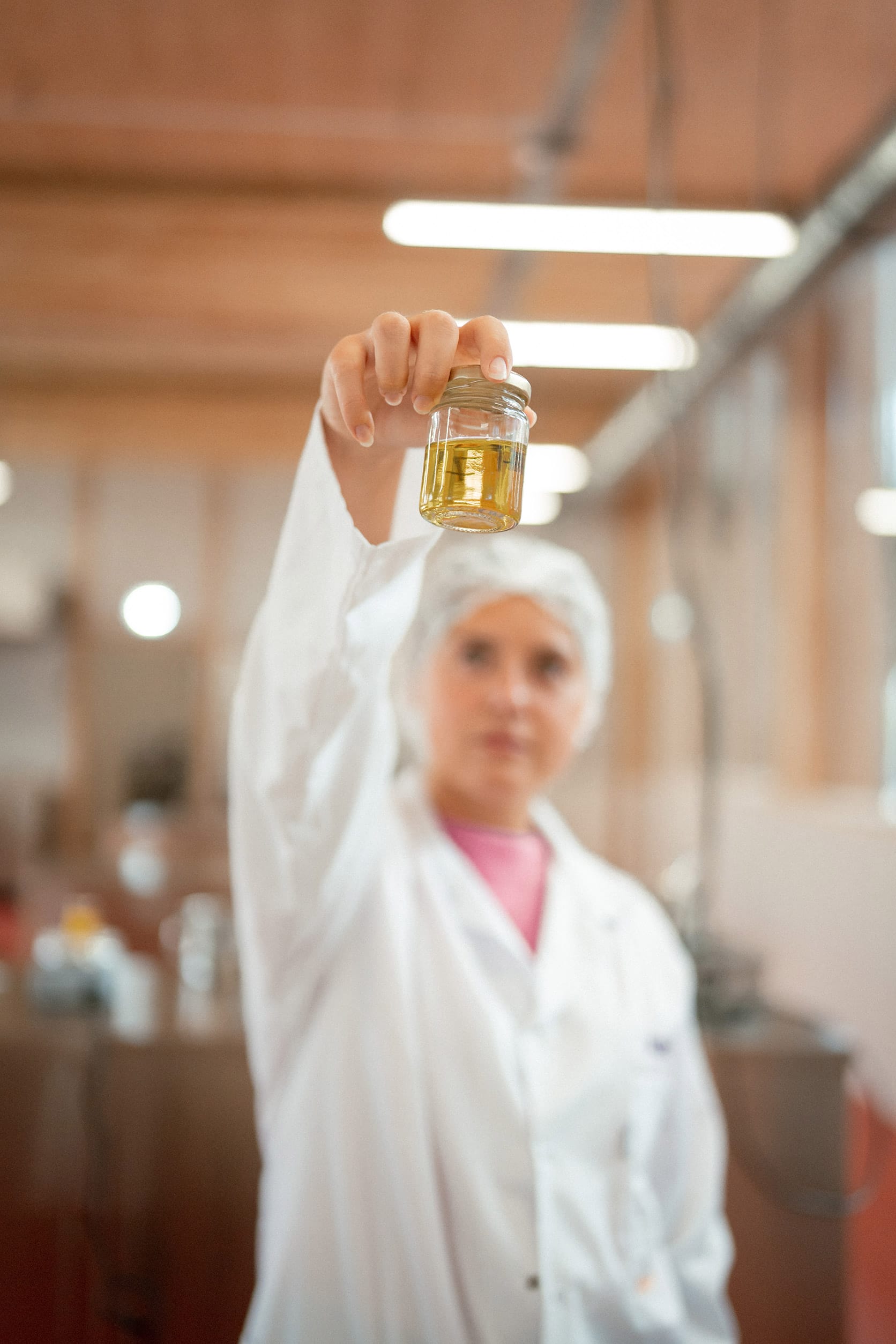 Une étudiante tient dans sa main un flacon rempli de liquide jaune