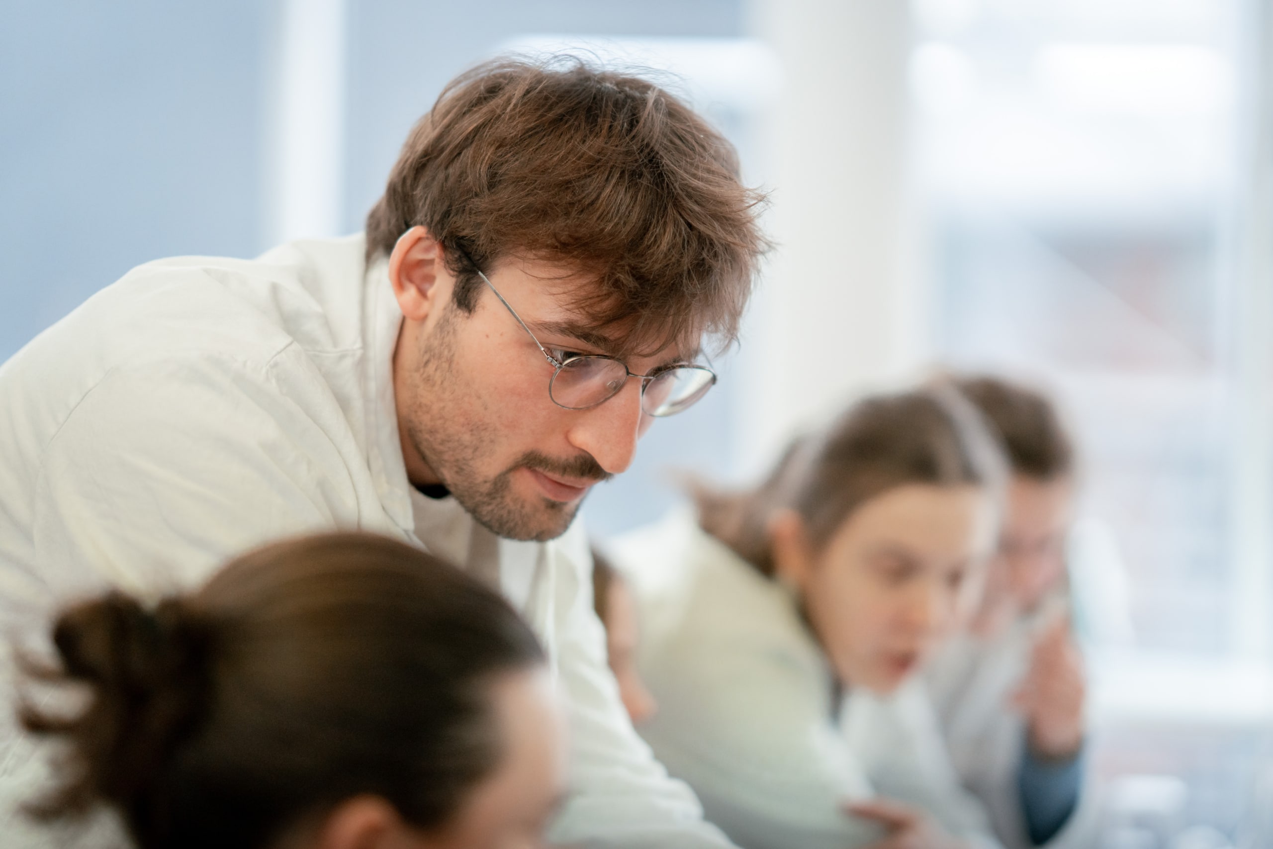 Un professeur en blouse blanche et avec des lunettes