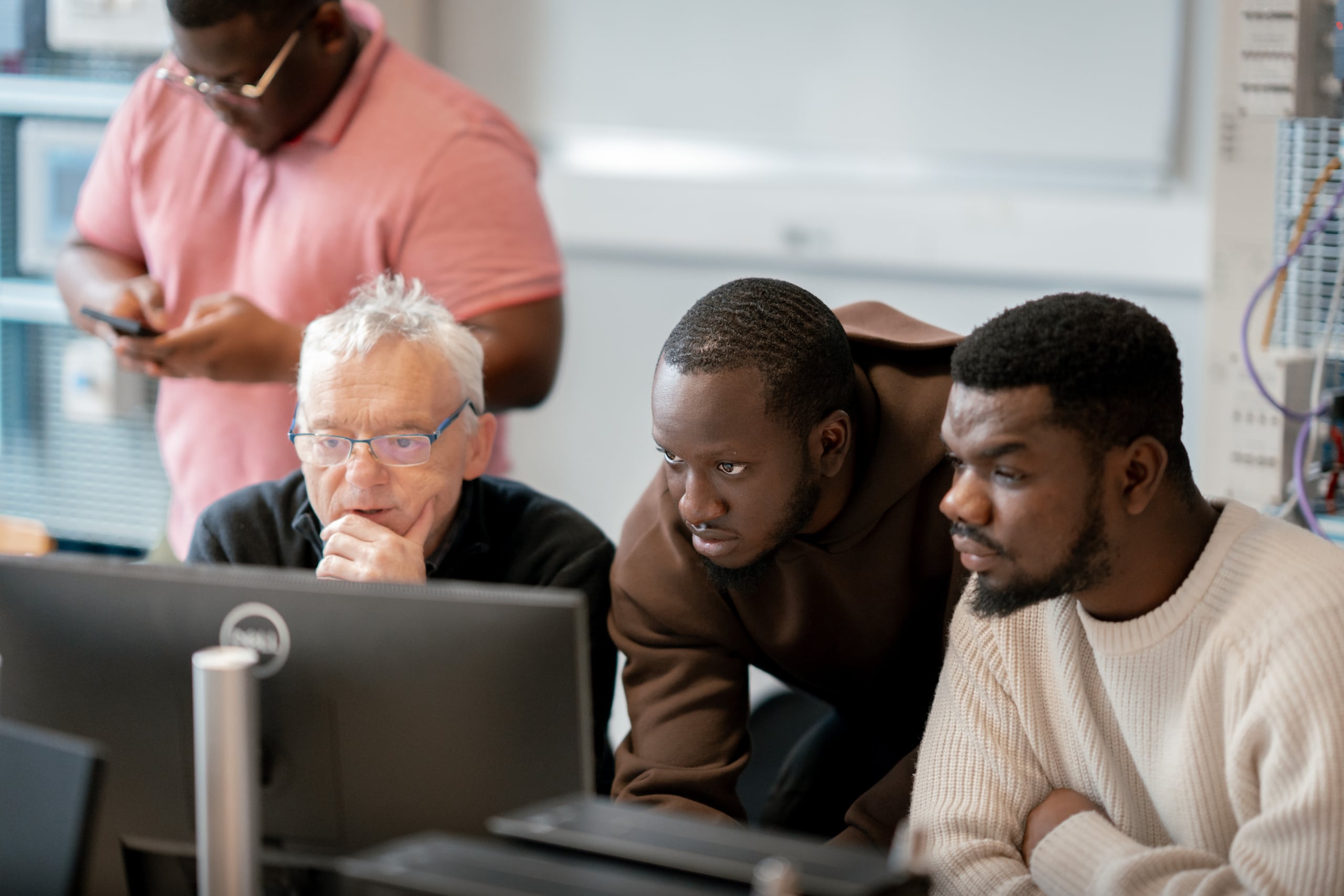 Students working with a teacher in front of a computer