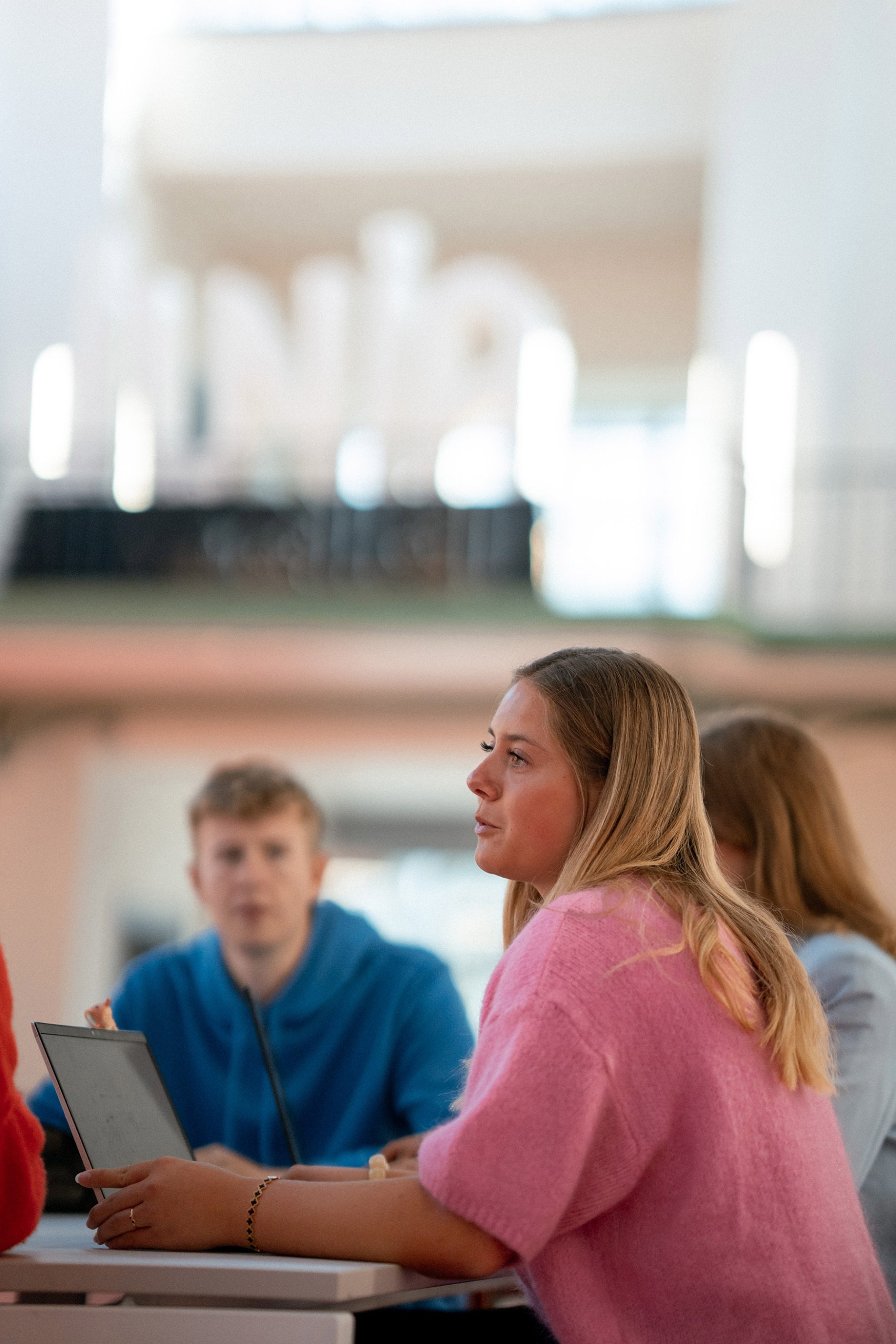 A student talking and working on her computer
