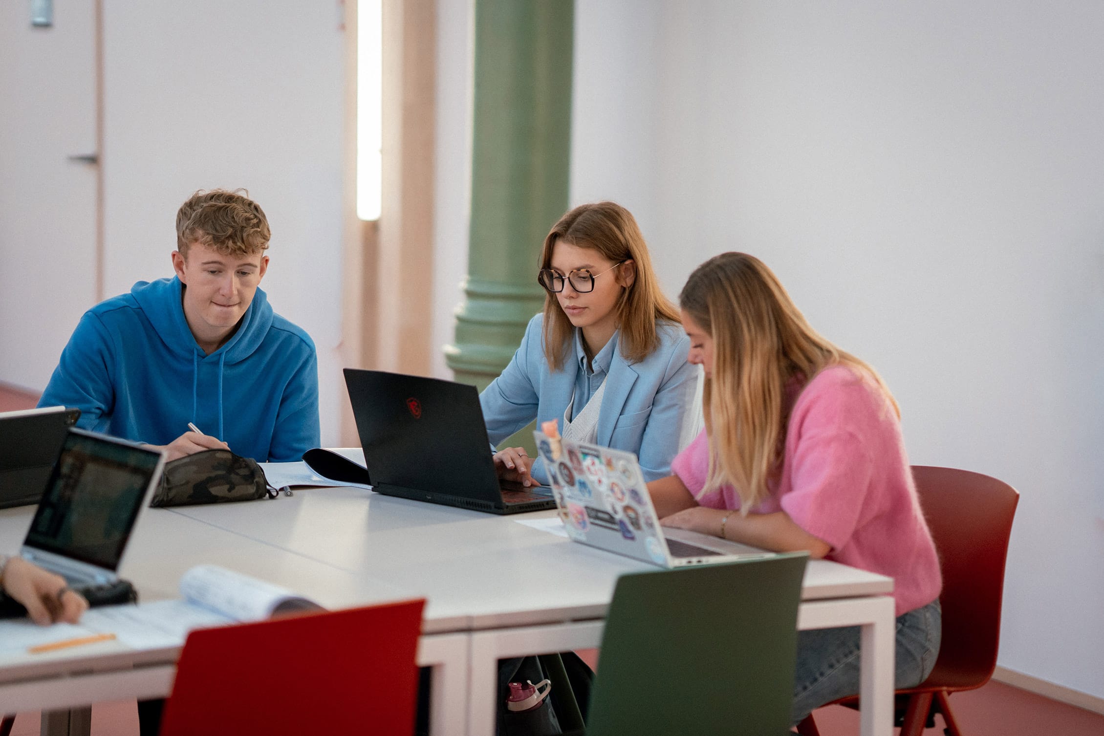 Students around a table with their computers