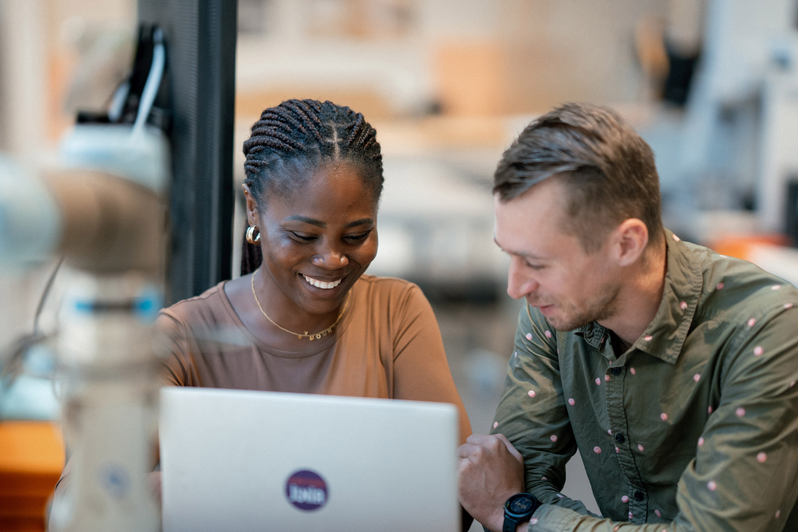 Students smiling and working together on a computer